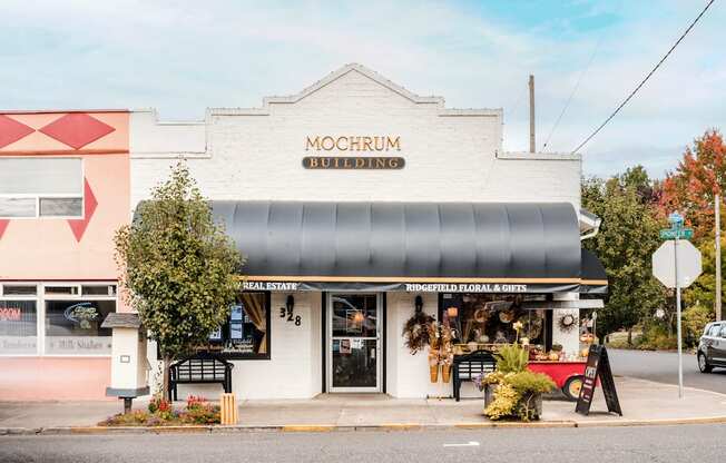 A white building with a black awning and a sign that says