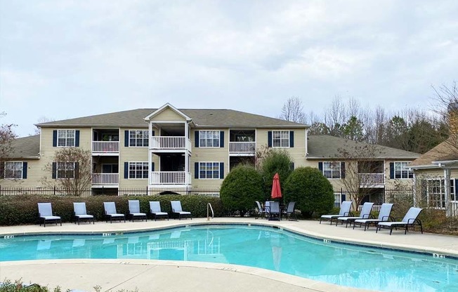 a large swimming pool in front of a large apartment building