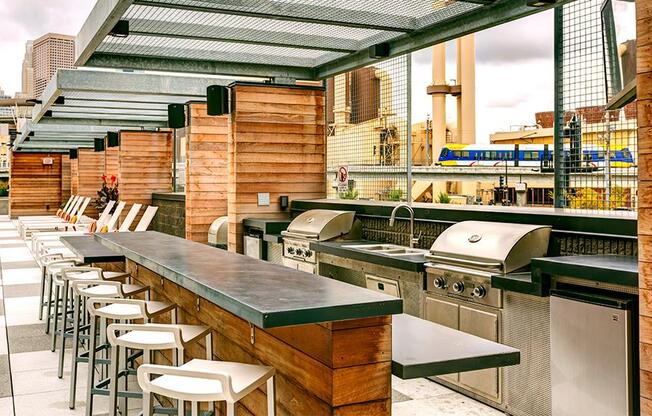 a bar with a row of bar stools and stainless steel appliances