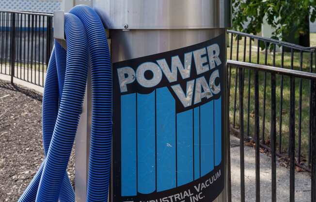 a power vac container with a blue hose plugged into it