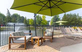 a patio with chairs and umbrellas at The Springs Apartment Homes, Michigan, 48377