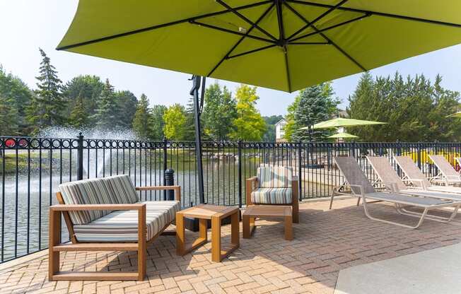 a patio with chairs and umbrellas at The Springs Apartment Homes, Michigan, 48377