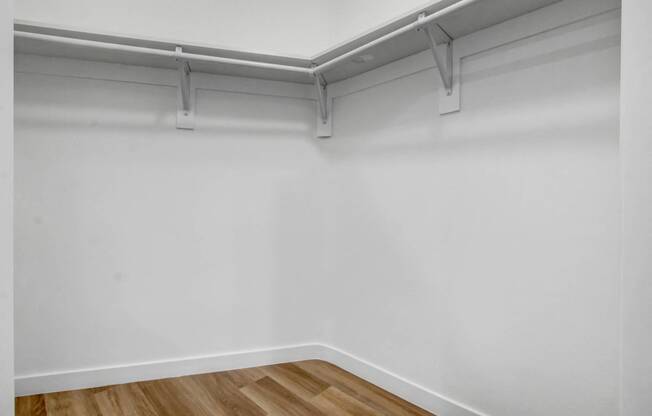 an empty room with white walls and a wooden floor