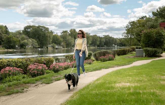 a woman walking her dog in a park at The View Apartments St Charles, Illinois