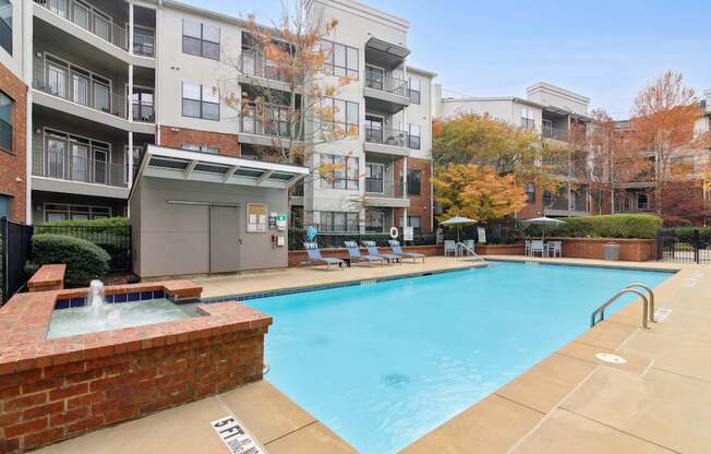 A large swimming pool in front of apartment buildings.