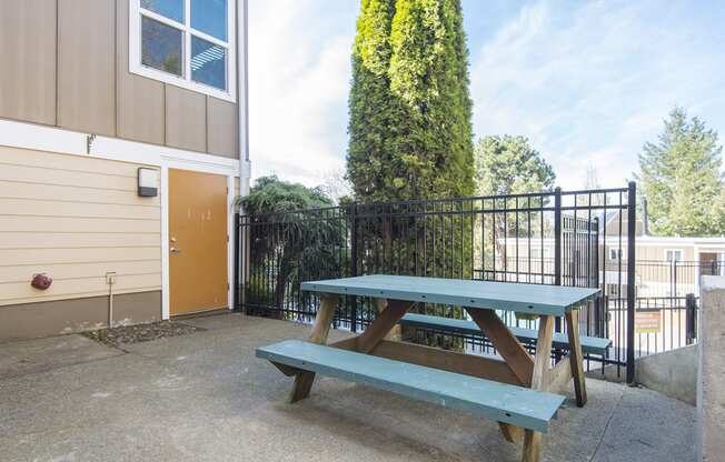 a picnic table with a bench in front of a building