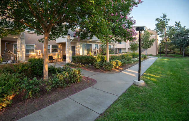 A residential area with apartment buildings and a sidewalk.