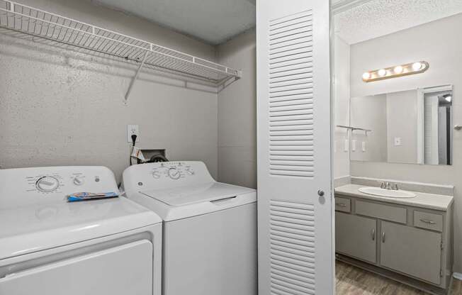A white bathroom with a washer and dryer.