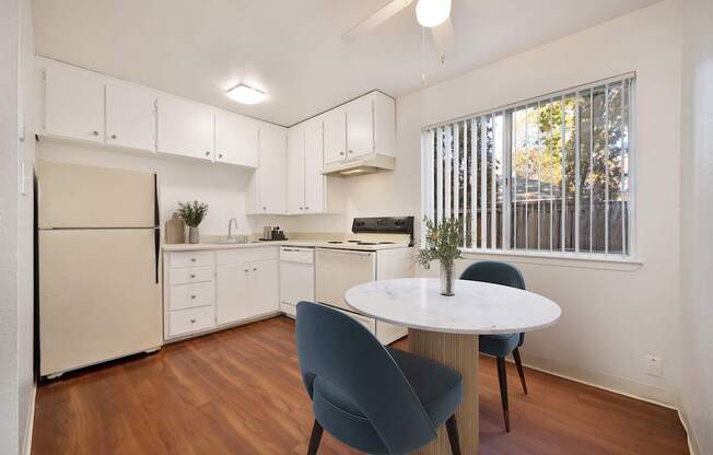 A kitchen with a table and chairs.