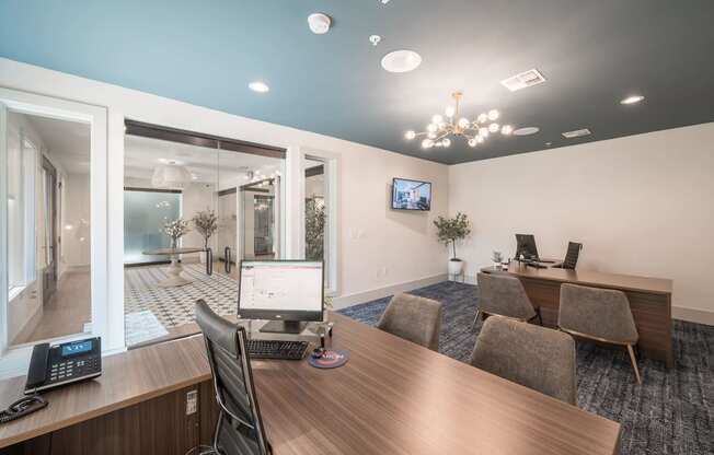 a conference room with a desktop computer on a wooden desk