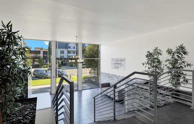 A staircase with a metal railing and a plant on the side.