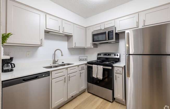 A kitchen with white cabinets and stainless steel appliances.