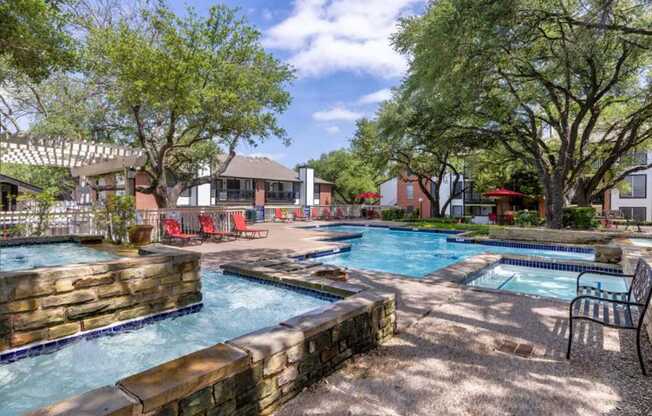 our apartments have a large pool with chairs and trees