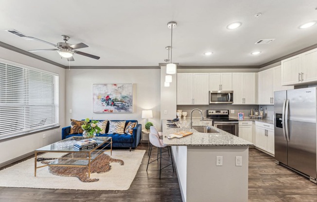 a kitchen and living room with stainless steel appliances and a granite counter top