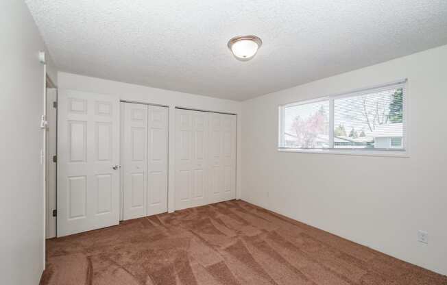 a bedroom with two closets and a window