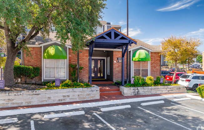 the front of a red brick building with green umbrellas