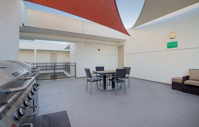 A modern outdoor kitchen with a grill and seating area.at Plaza Lafayette, Los Angeles, 90057  