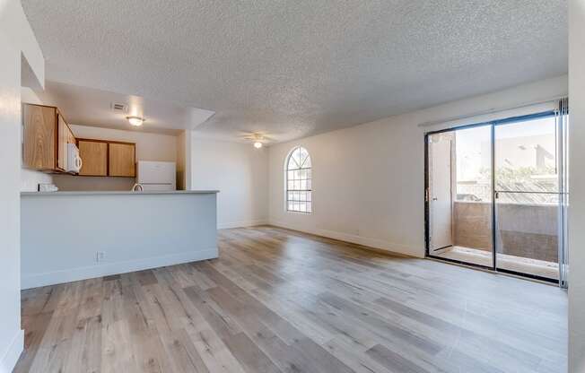 an open living room and kitchen with a sliding glass door to a balcony at Pacific Harbors Sunrise Apartments, Las Vegas, NV