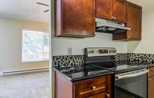 a kitchen with a stove top oven next to a window at The Bluffs at Mountain Park, Lake Oswego, OR