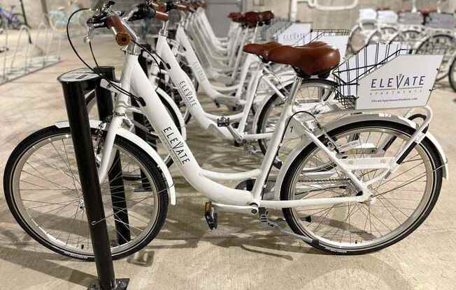 A row of bicycles are parked and have a sign that says Elevate.