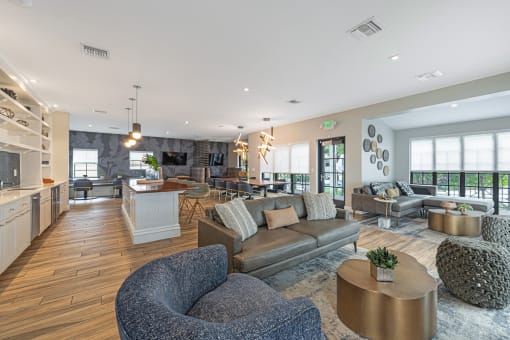 a living room with couches and chairs and a kitchen