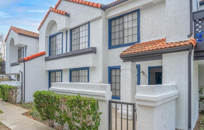 a white building with blue windows and a sidewalk  at The Resort at Encinitas Luxury Apartment Homes, Encinitas, CA