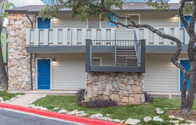 a stone building with a balcony and a blue door