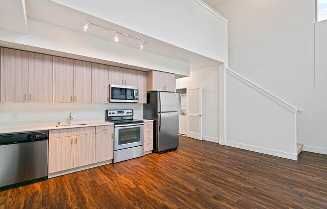 A kitchen with wooden floors and stainless steel appliances.