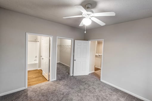 an empty room with a ceiling fan and a closet