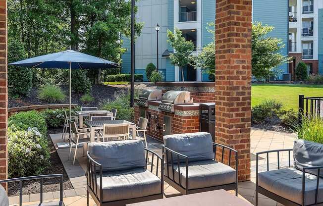 a patio with chairs and tables and an umbrella