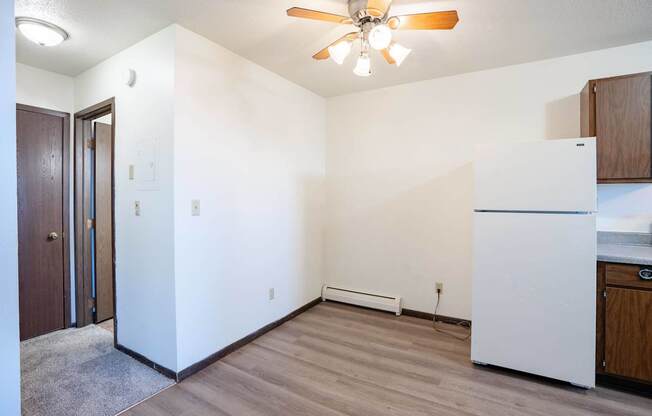 A kitchen with a white fridge and a ceiling fan. West Fargo, ND Parkwest Gardens