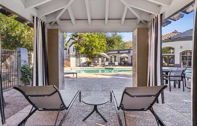 Two chairs and a table are on a patio.
