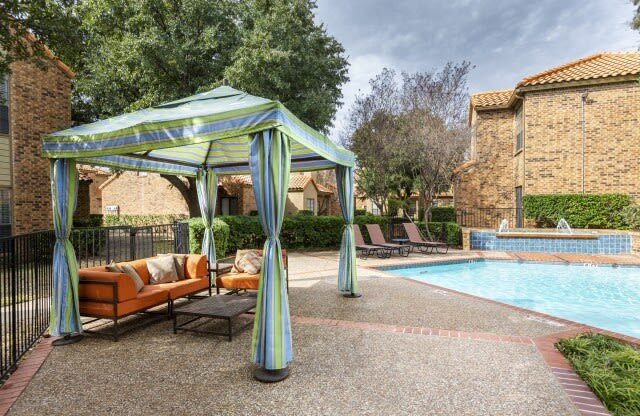 a swimming pool with a gazebo and chairs next to it