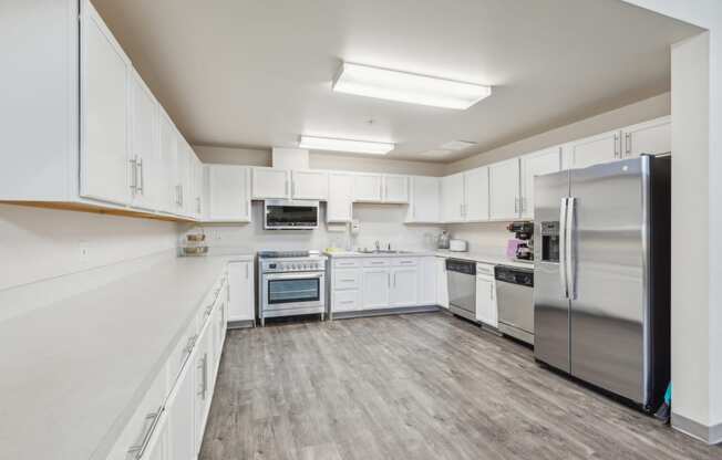 a large kitchen with white cabinets and stainless steel appliances