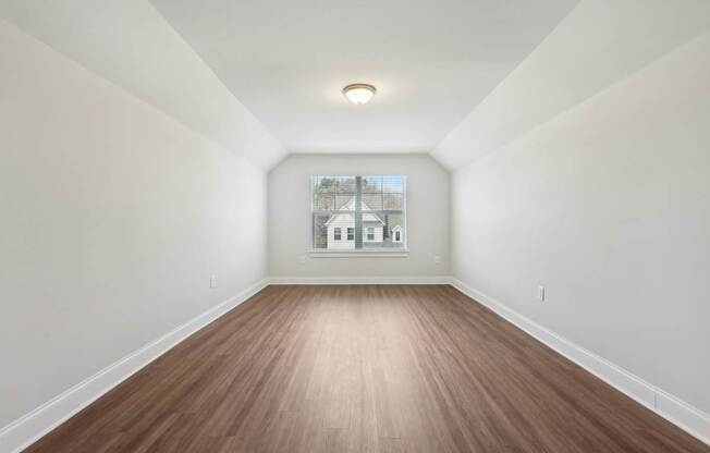 A room with wooden flooring and white walls.