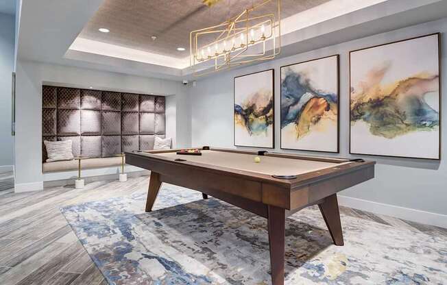 A pool table in a room with a large painting on the wall.