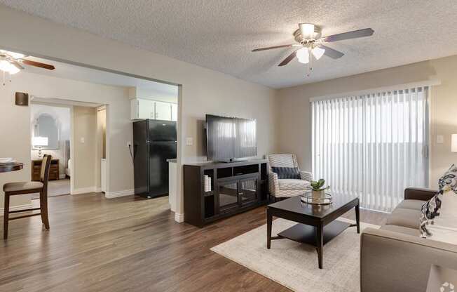 A living room with a wooden floor and a ceiling fan.