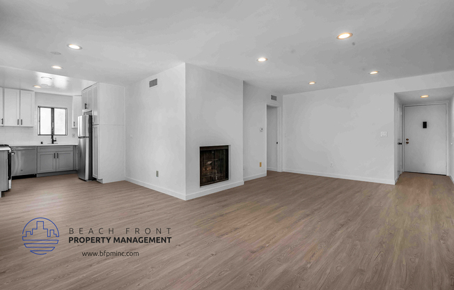 a large living room with hardwood floors and white walls