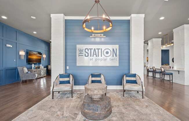 a living room with blue walls and a lobby with chairs and a table