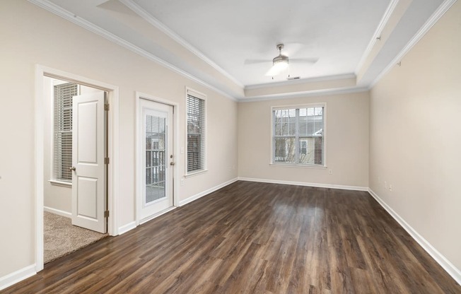 an empty living room with wood flooring and a white door