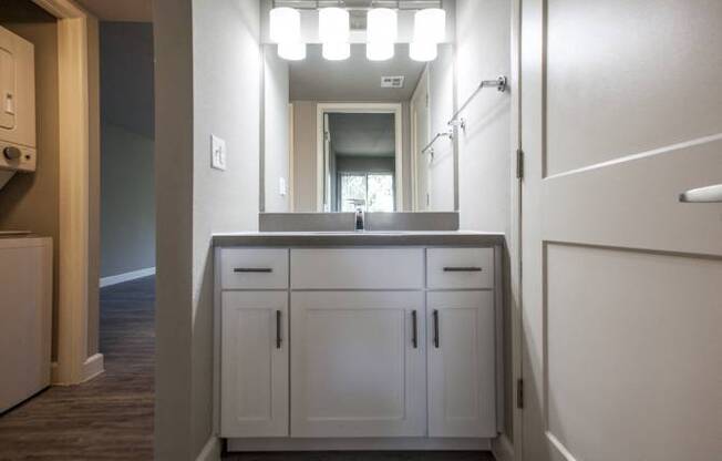 A bathroom with a vanity and a mirror.
