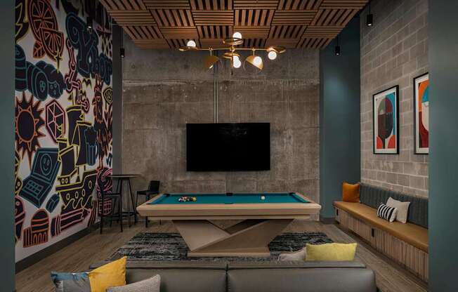 A room with a pool table and a television.