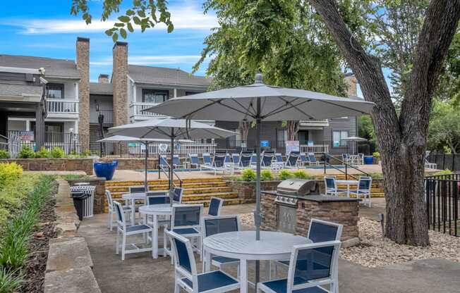 a patio with tables and chairs and umbrellas