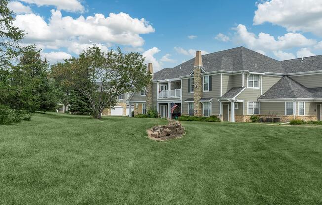 a large green field in front of a house