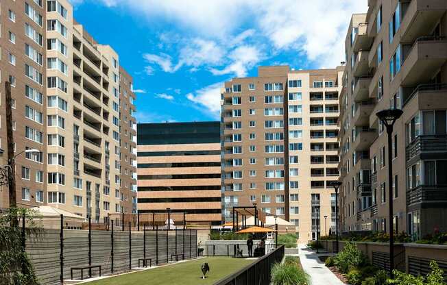 a view of a courtyard between two tall buildings and a park