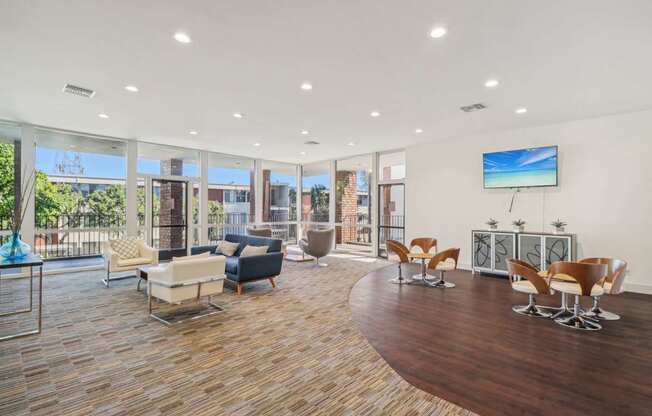 A living room with a wooden floor and a large TV mounted on the wall.