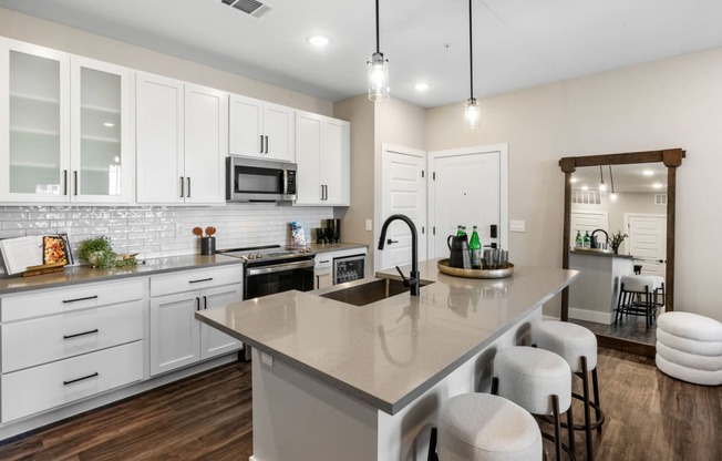 a kitchen with a large island and white cabinets