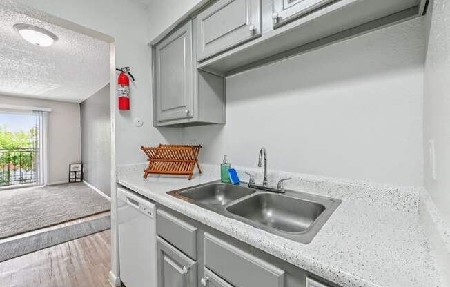 A kitchen with a white countertop and grey cabinets.