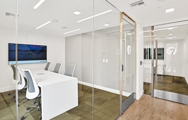 a conference room with a white table and chairs