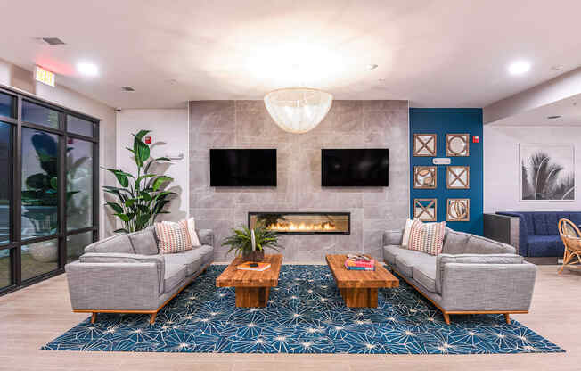 A modern living room with a fireplace and grey couches.